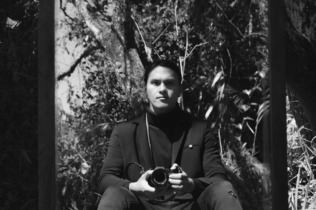 Danish documentary photographer holding a camera on a town street